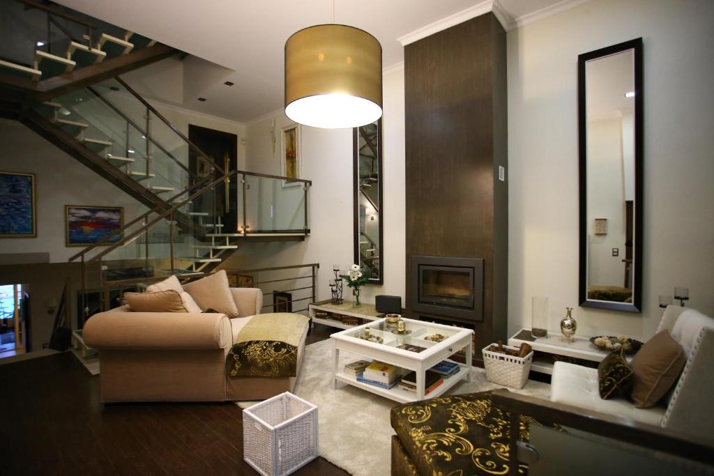 ein Wohnzimmer mit einem Sofa und einer Treppe in der Unterkunft Opus One Luxury Guest House & Wine in Faro