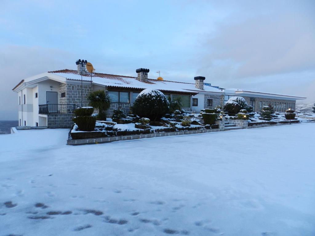una casa en la nieve con huellas en la nieve en Albergaria Senhora do Espinheiro, en Seia