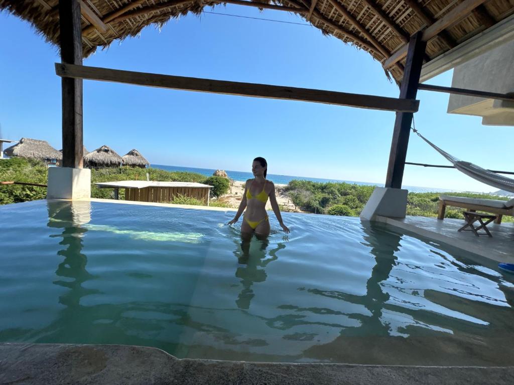 a woman standing in the water in a swimming pool at Casa Gitana in Chamuscadero