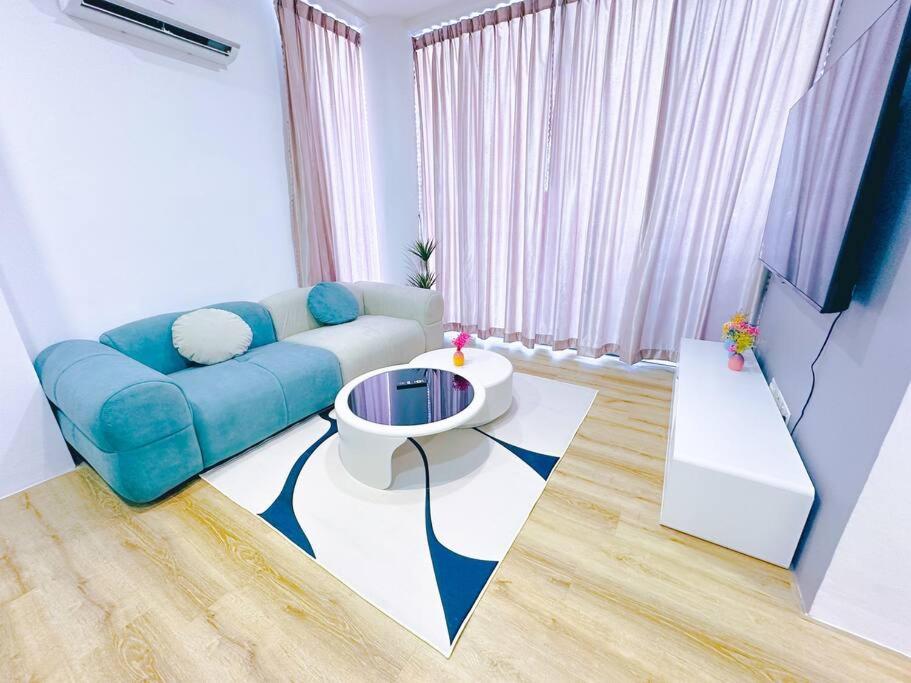 a living room with a blue couch and a table at Hanns modern paradise in Sibu