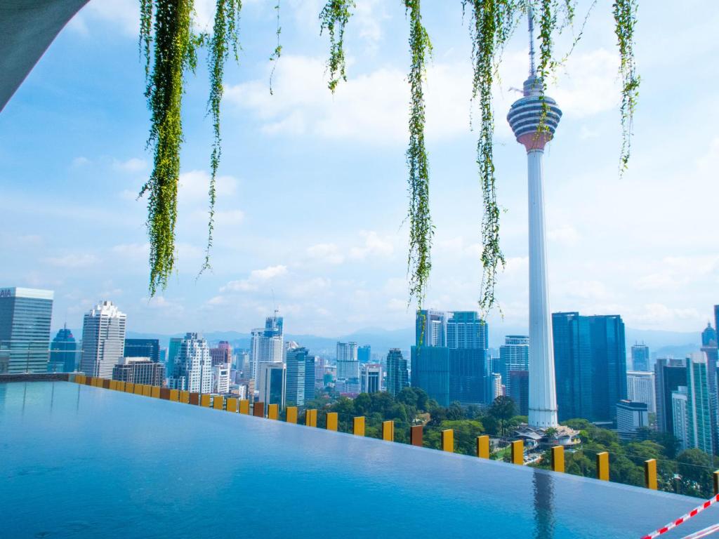 クアラルンプールにあるCeylonz Suites KLCC Rooftop Infinity Pool KL Tower Viewの市街のスカイラインを背景にしたスイミングプール