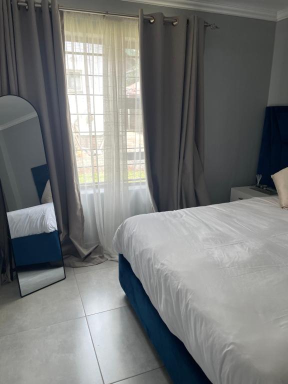 a bedroom with a bed and a large window at Masana at Homely Escape in Phalaborwa