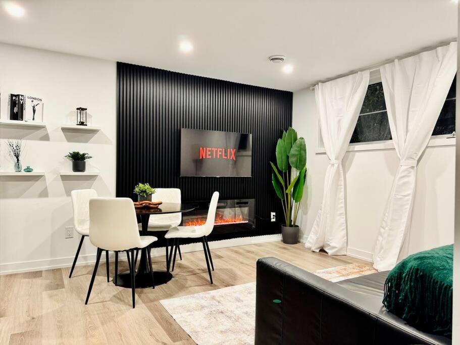 ein Wohnzimmer mit Tisch und Stühlen und einem Fernseher in der Unterkunft Luxury Stay Near Niagara Falls in Niagara Falls