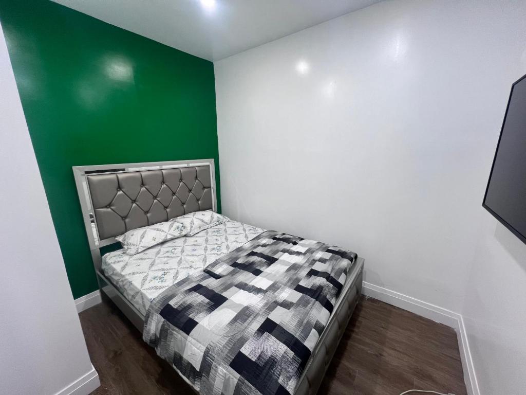a bedroom with a bed with a green and white wall at Private Bathroom Room In Cambridge B7 in Cambridge