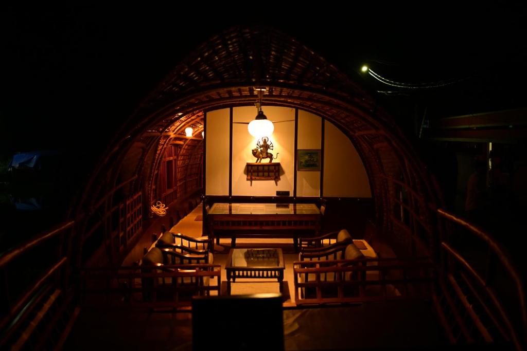a room with chairs and a table and a light at Thara's Houseboat in Alleppey