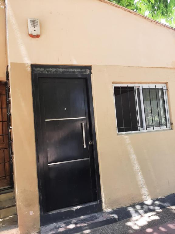 eine schwarze Tür an der Seite eines Gebäudes in der Unterkunft Andino in La Cieneguita