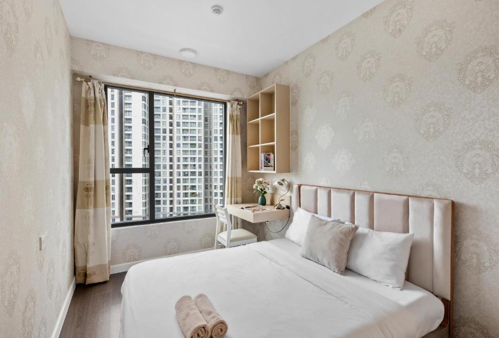 a bedroom with a bed with a desk and a window at Căn hộ Rivergate - Sài Gòn, Quận 4 in Ho Chi Minh City