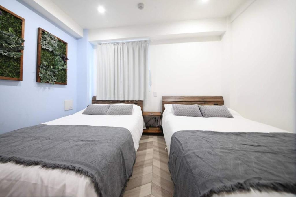 een slaapkamer met twee bedden en een raam bij Shibuya WAVE 302 in Tokyo