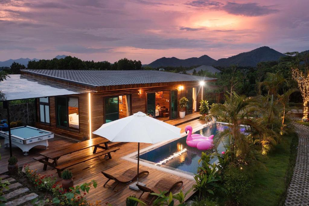 a house with a swimming pool and a pink flamingo at Mimi's House Sóc Sơn - Venuestay in Ấp Ðông Ðô
