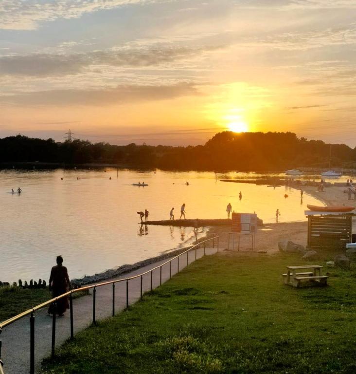 a group of people swimming in the water at sunset at Gorsehill 44 in Lytchett Minster
