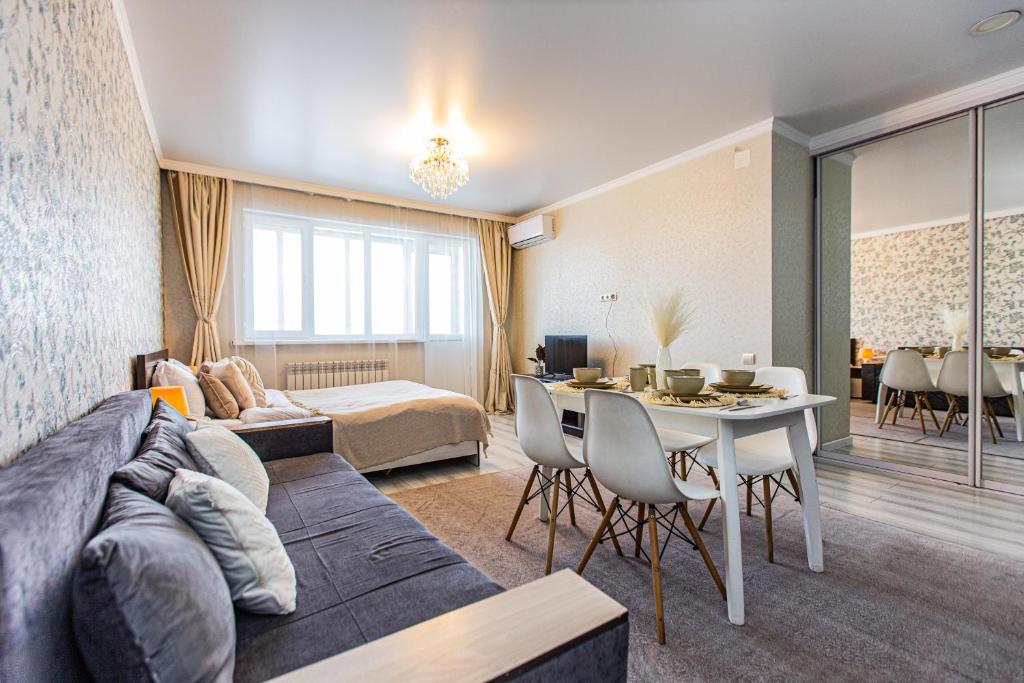 a living room with a couch and a table at Ушсункар Nice in Almaty