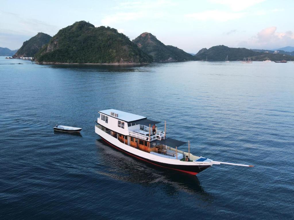 un bateau flottant sur une grande étendue d'eau dans l'établissement KLM Senayla, à Labuan Bajo