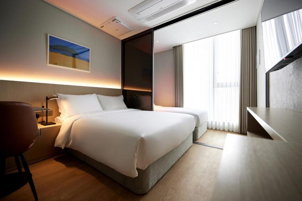 Postel nebo postele na pokoji v ubytování Homes Stay Myeongdong