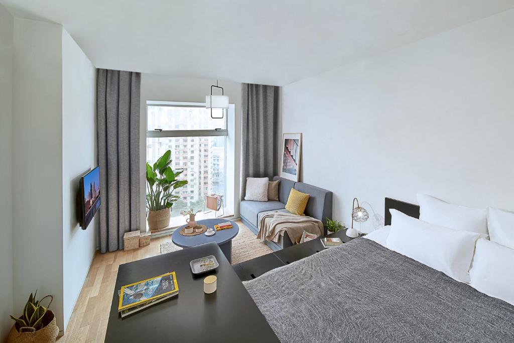 上海市にあるbase-Shanghai SUHE Serviced Apartment, Near East Nanjing Road & People's Squareのベッドとリビングルームがあるホテルの部屋