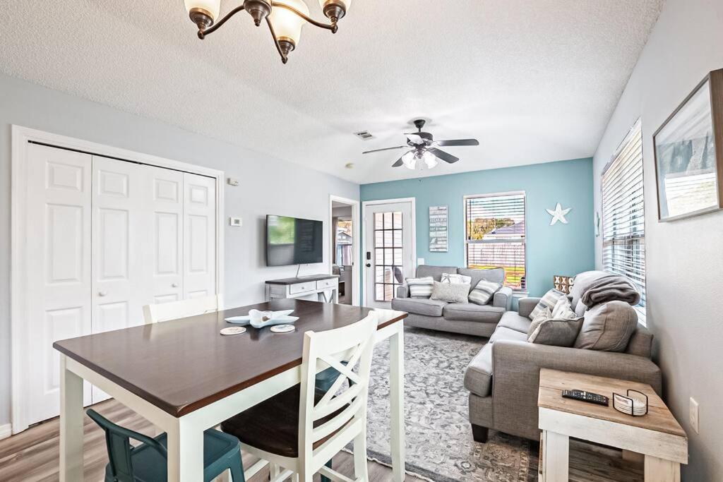 un soggiorno con un tavolo e un divano di Surfside Cottage - Charming Quiet 3BD 2BA House - Private Beach Access, Close to Navarre Beach & Gulf Breeze Zoo a Gulf Breeze