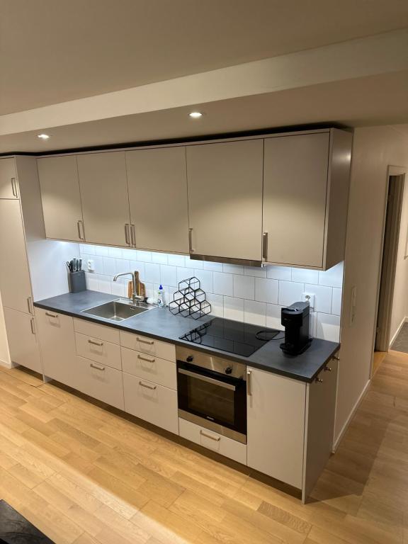 a kitchen with white cabinets and a black counter top at Trump apartment in Stockholm