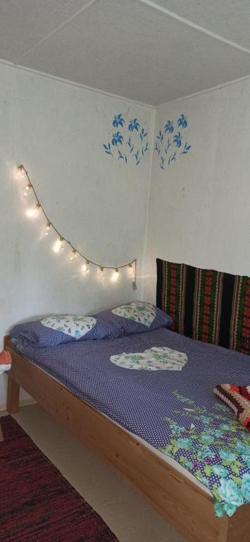 a bedroom with a bed with lights on the wall at Siedlisko Urszulanka Domek in Policzna