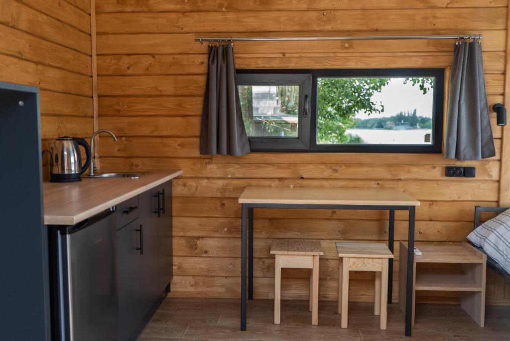 una cocina con mesa en una casa pequeña en Будиночок з панорамою на річку, en Kudashevka