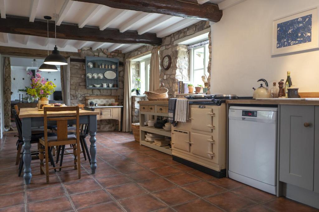 a kitchen with a table and a dining room at Little Underhill in Oswestry