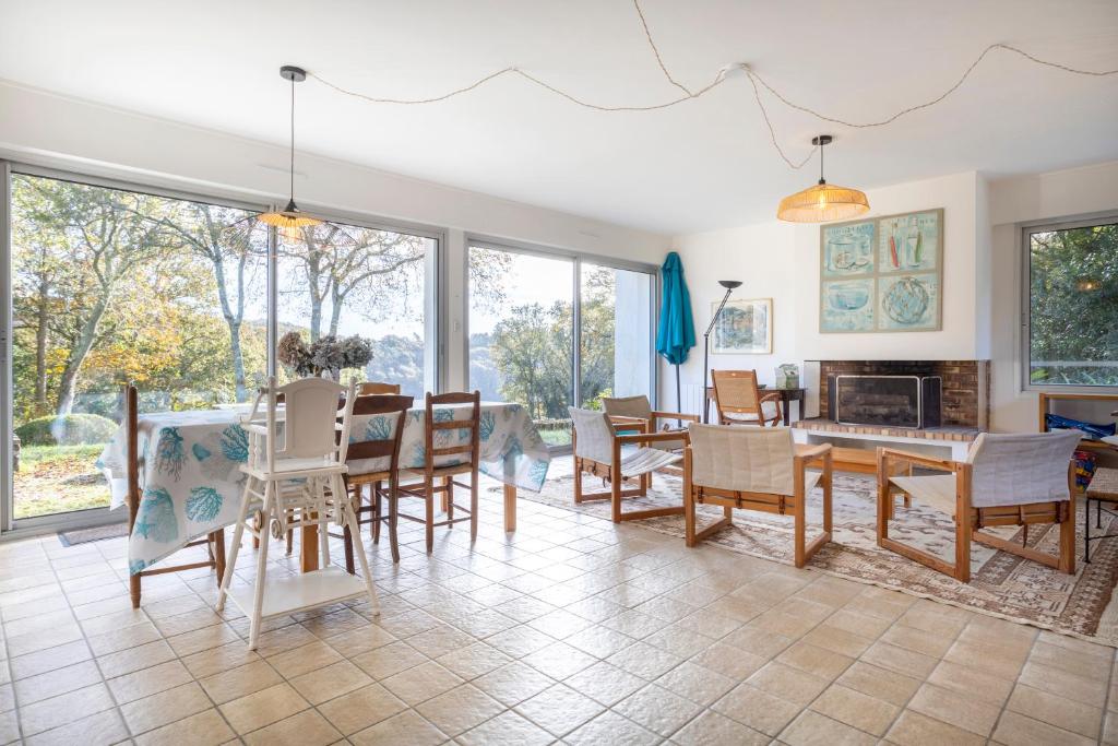 un salon avec une table et des chaises dans l'établissement Maison vue sur la Laïta 2 kms plage, à Clohars-Carnoët
