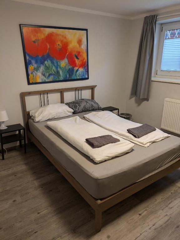 a bed in a bedroom with a painting on the wall at NestOaseWHV Zentrale Zimmer zwischen City und Südstrand in Wilhelmshaven