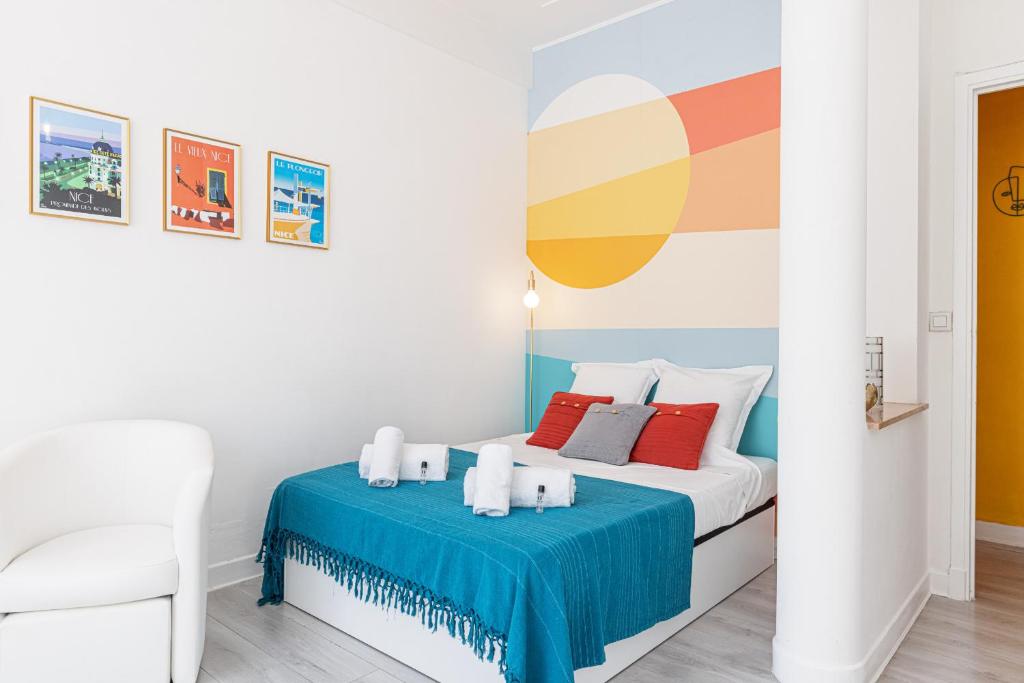 - une chambre blanche avec un lit et une couverture bleue dans l'établissement 37 LAMARTINE - Magnifique Studio Art Deco - Centre-ville, à Nice