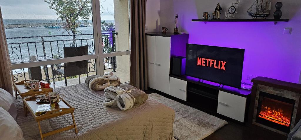 a living room with a tv and a fireplace at Apartment Porto Chernomoretz in Chernomorets