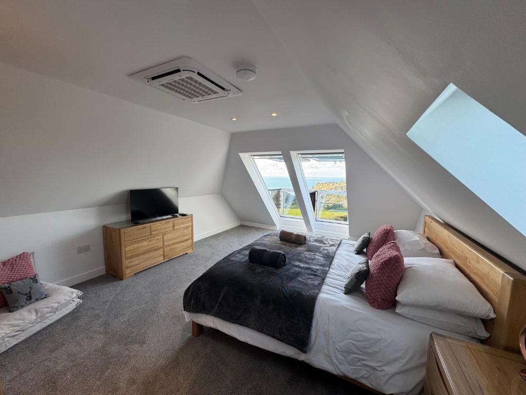 une chambre avec un lit, une télévision et une fenêtre dans l'établissement Camelot House 1 Bed Duplex Sea View Cabrio Balcony, à Tintagel