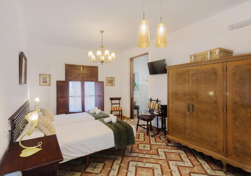 a bedroom with a bed and a dresser at Art Boutique La Casona de las Flores in Ondara