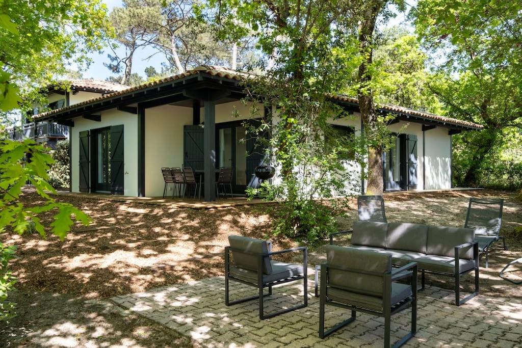 une terrasse avec des chaises et une maison dans l'établissement Villa Chambrelent - Pyla sur Mer - proche de la plage, à La Teste-de-Buch