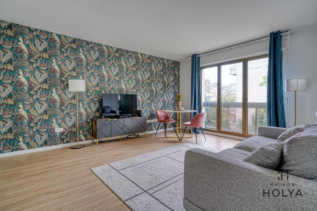 un salon avec un canapé et une télévision dans l'établissement Le Noble - À Neuilly-sur-Seine - 330B, à Neuilly-sur-Seine