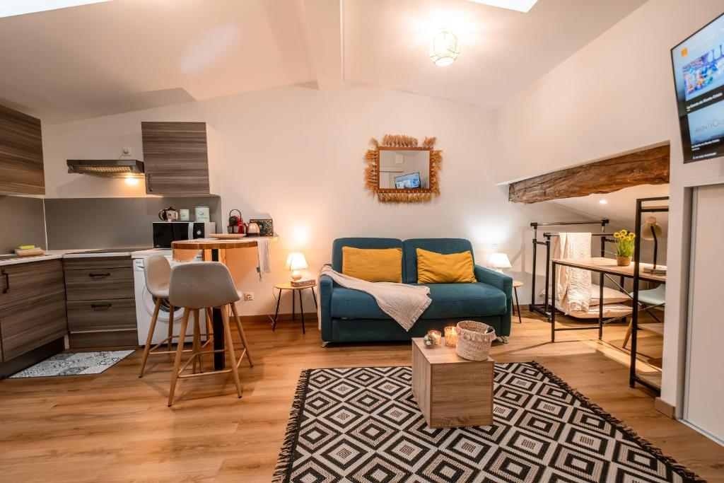 un salon avec un canapé bleu et une cuisine dans l'établissement Marie-Rose au Faubourg - Charmant studio en plein cœur de Montauban, à Montauban