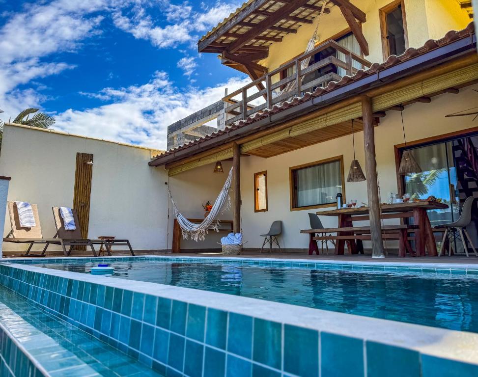 a villa with a swimming pool and a house at Casa do Alto Residence in Porto Seguro