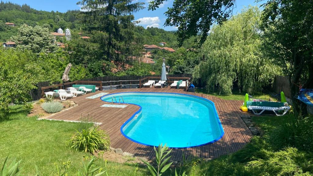 a swimming pool in a yard with chairs and a yard at Lavender and Poppy cottages in Bebrovo