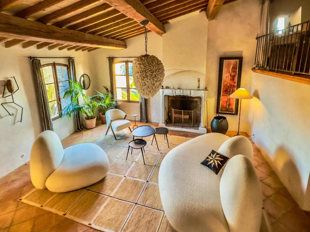 - un salon avec deux chaises blanches et une cheminée dans l'établissement Maison Bellevue, à Gassin