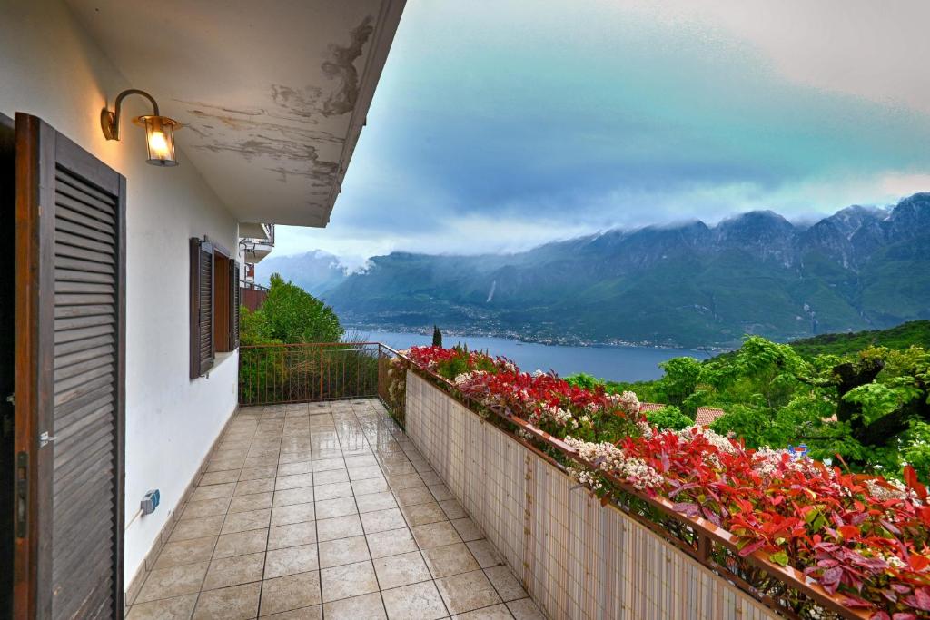 balcón con flores y vistas al lago en Appartamento Il Gufo - Theater Home, en Tignale