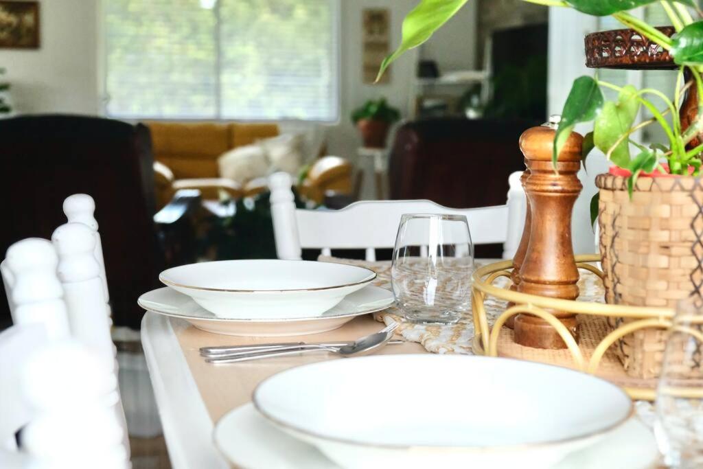 a dining room table with plates and glasses on it at 87 on Crescent in Gympie