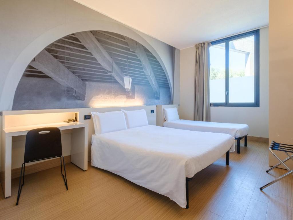 Łóżko lub łóżka w pokoju w obiekcie B&B Hotel Ravenna