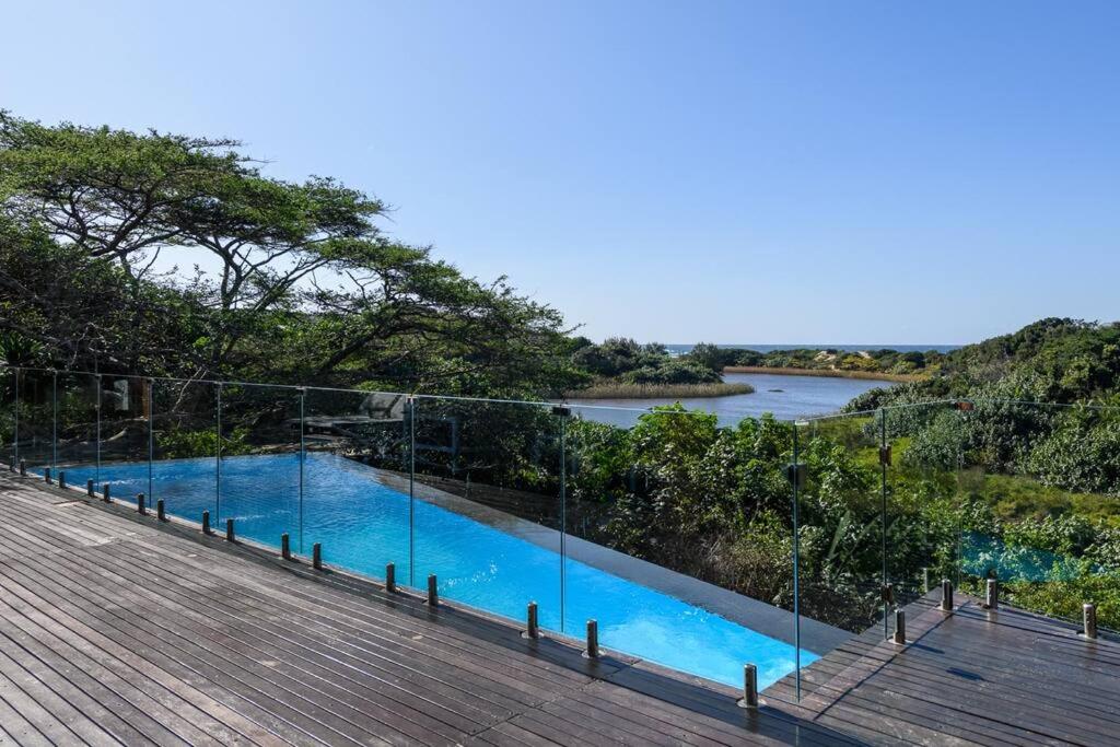 une piscine avec une rivière en arrière-plan dans l'établissement San Lameer Villa 1604 - 4 Bedroom Premier - 8 pax - San Lameer Rental Agency, à Southbroom