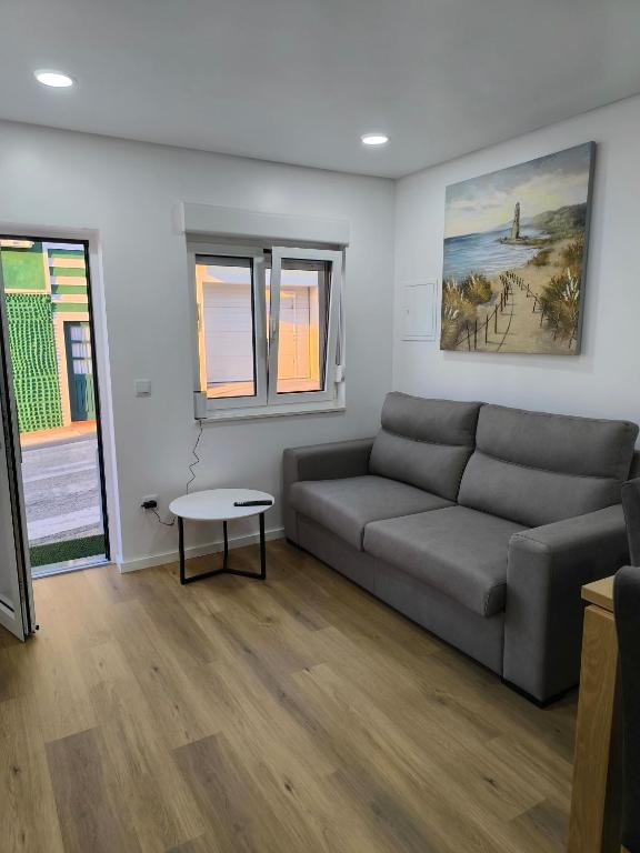 a living room with a couch and a table at Alojamento do Emílio in Gafanha da Encarnação