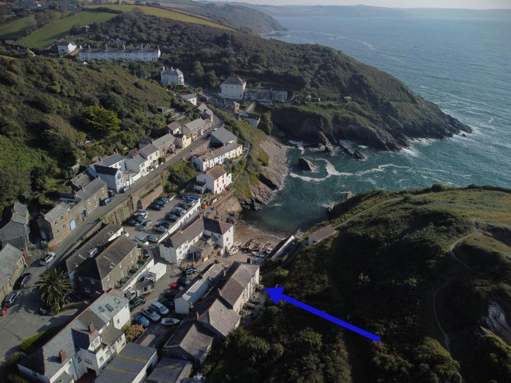 una vista aerea di un villaggio su una collina vicino all'oceano di Cove Cottage a Portloe