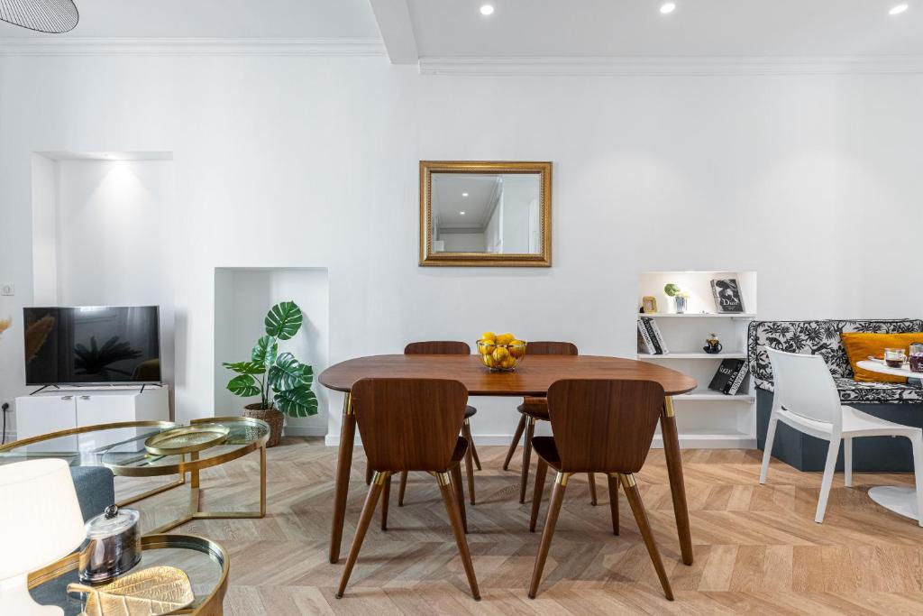 un salon avec une table et des chaises en bois dans l'établissement 37 MASSENA LOT 2 - Superbe 3 pieces - Zone Pietonne - A-C, à Nice