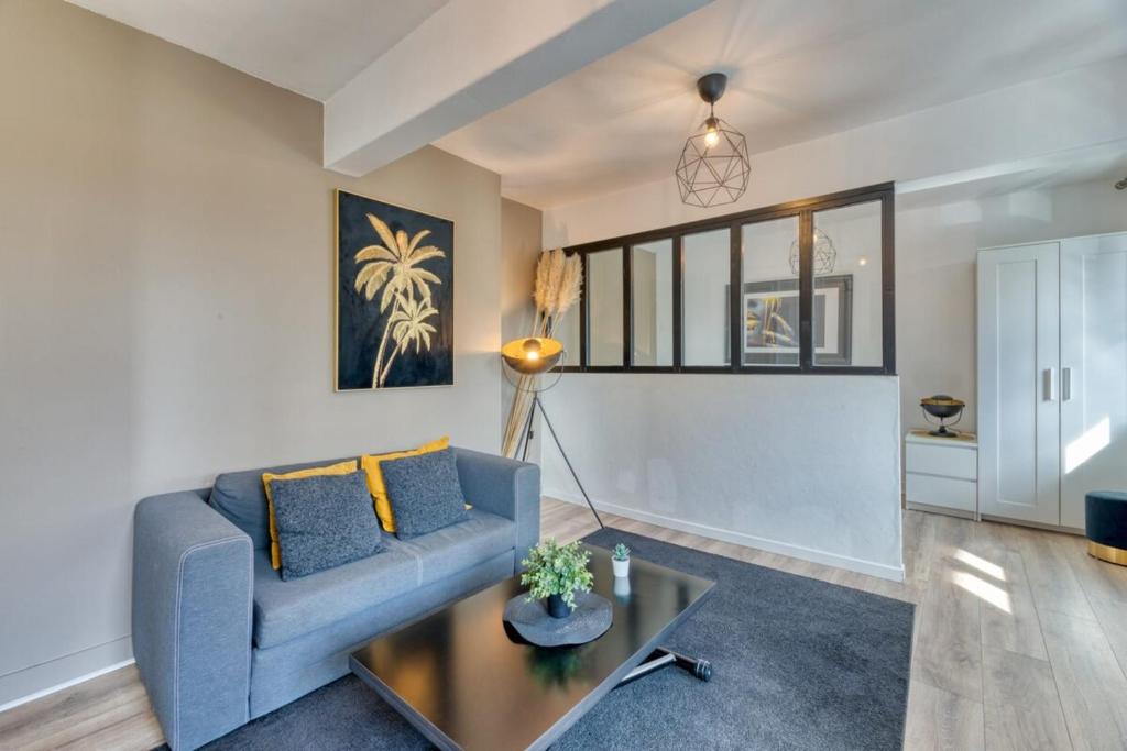 un salon avec un canapé bleu et une table dans l'établissement Le Golden Black à Rouen !, à Rouen