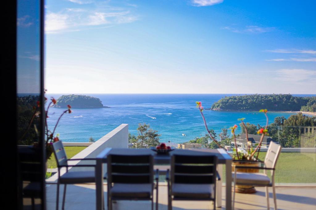 a table and chairs with a view of the ocean at The heights luxury sea view 2BR near Kata Beach in Kata Beach
