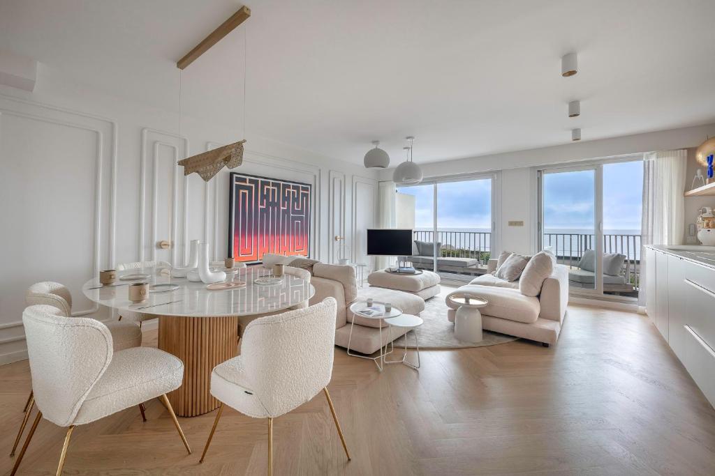 un salon blanc avec une table et des chaises dans l'établissement Appartement de standing en front de mer, pour 4, à La Baule