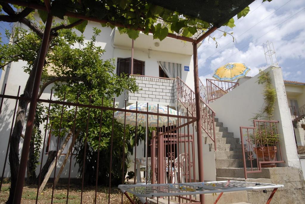 a white house with stairs and a table in front of it at Apartments Bilić in Vis
