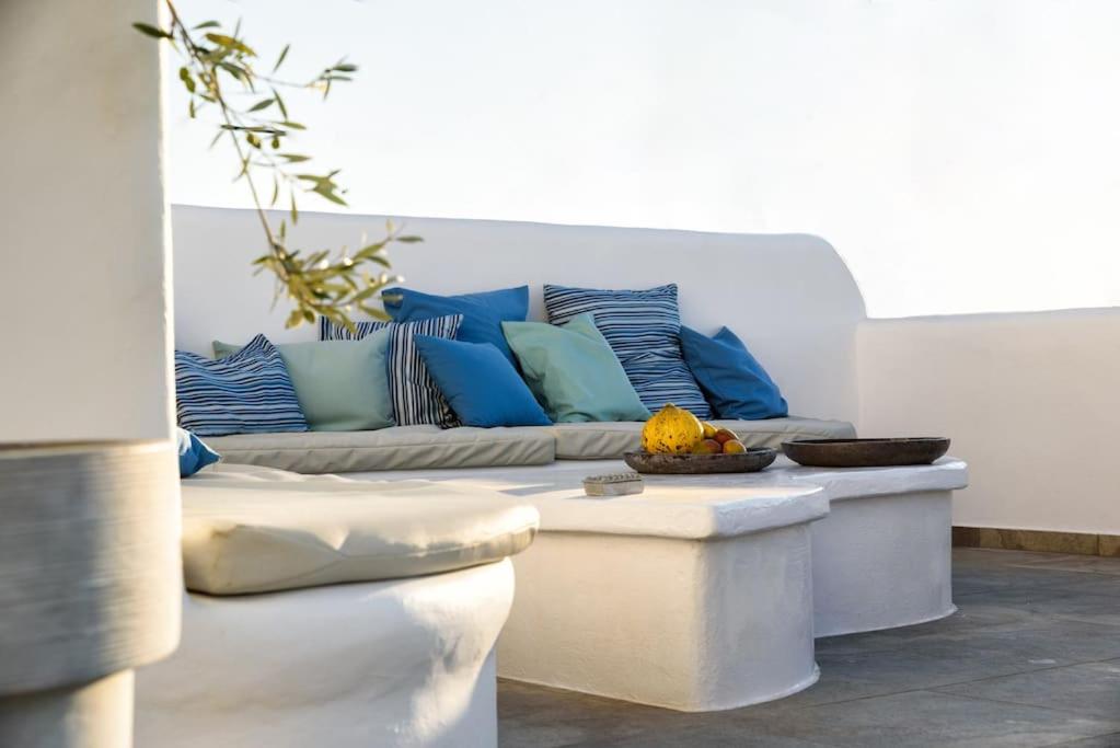 een woonkamer met een bank met blauwe kussens bij Villa Hara Naousa in Naousa