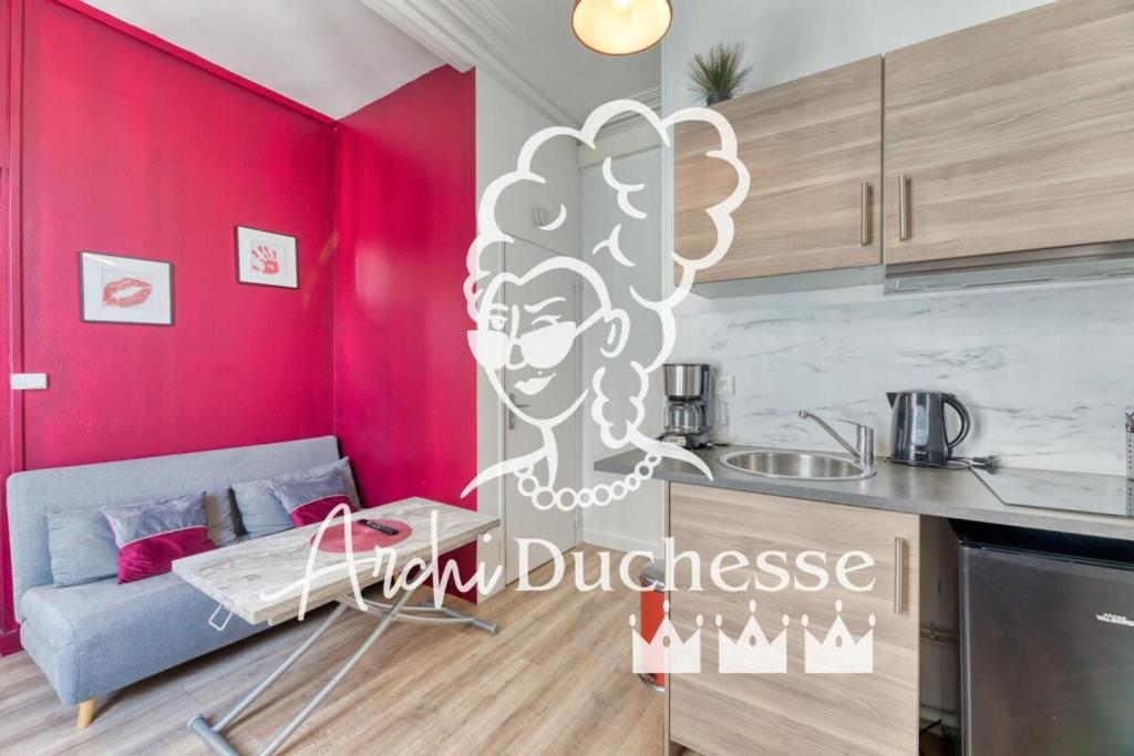 un salon avec un canapé et une cuisine dans l'établissement Le Red Touch votre F2 au cœur de Rouen !, à Rouen