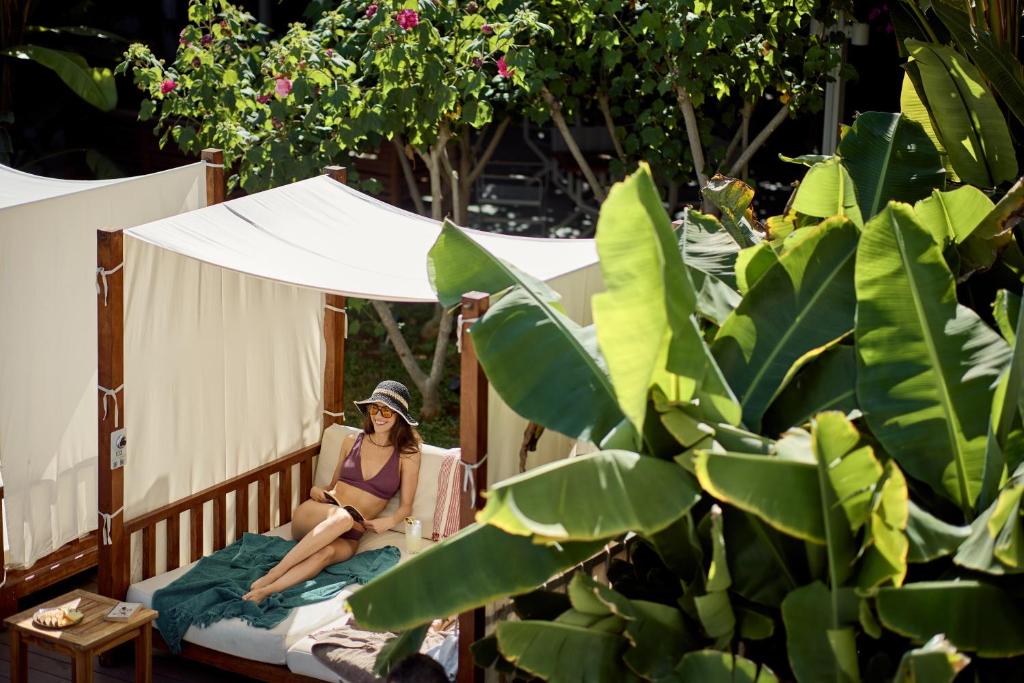 a woman in a bikini sitting on a bed at Nissi Park Hotel in Ayia Napa