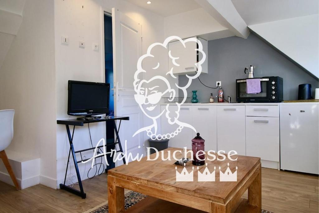 un salon avec une table et une cuisine dans l'établissement Le Petit Nid en plein centre-ville de Rouen !, à Rouen